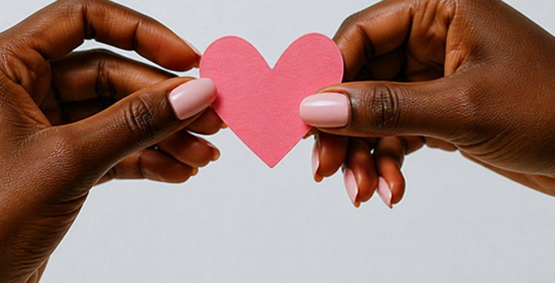 Two hands holding a paper heart